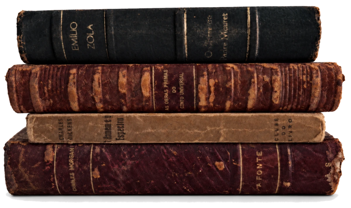 Pilha de quatro livros antigos encadernados em couro e tecido, do acervo da Síngula.